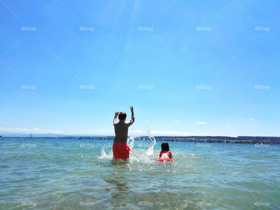 vacations, summer day, children playing in water