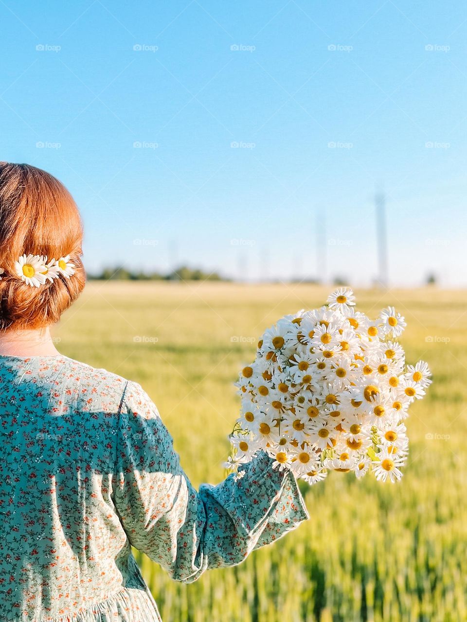 A woman with a bouquet of wild daisies