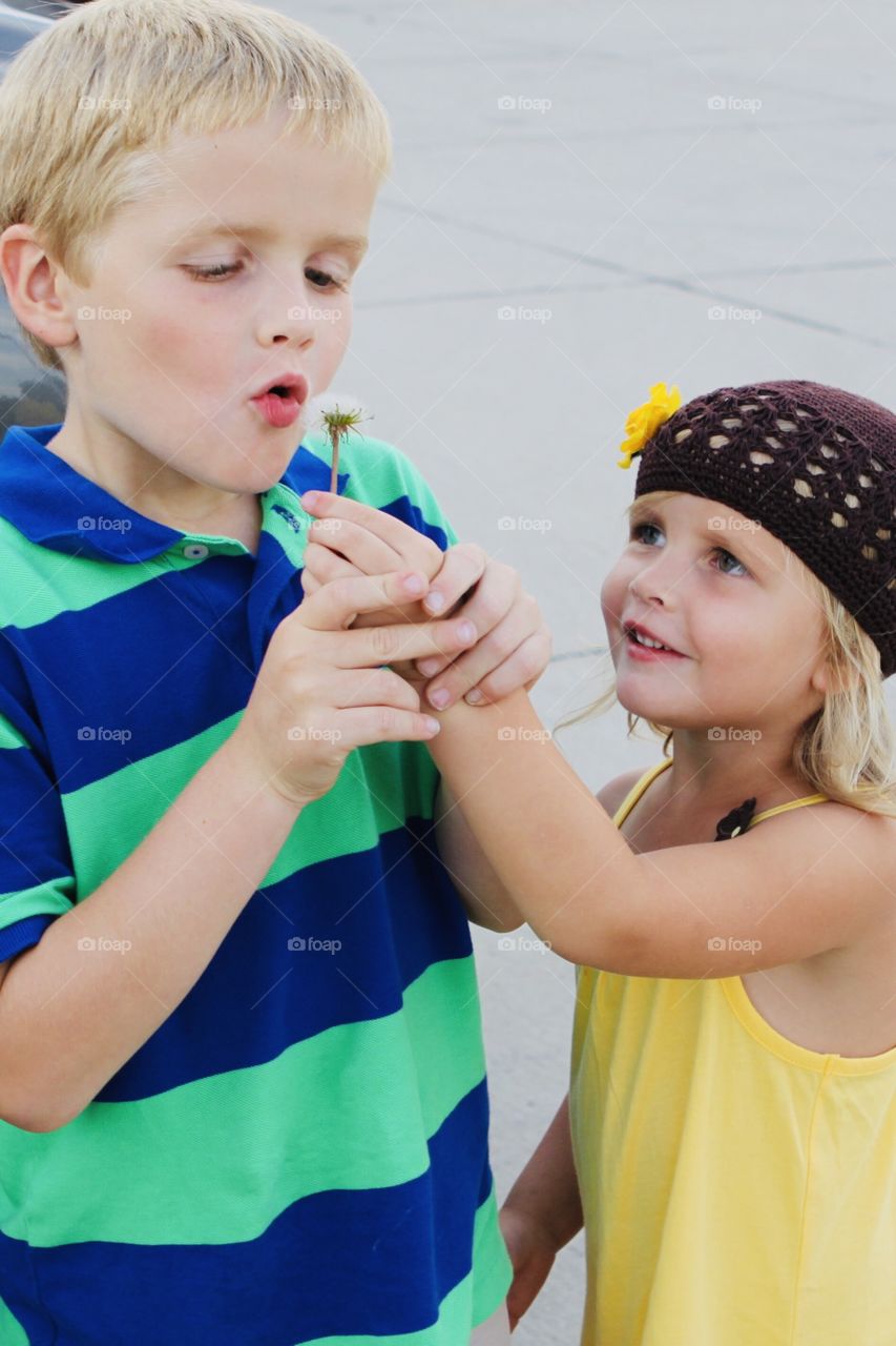 Super sweet photo of two children holding hands and playing with a dandelion they found!! 