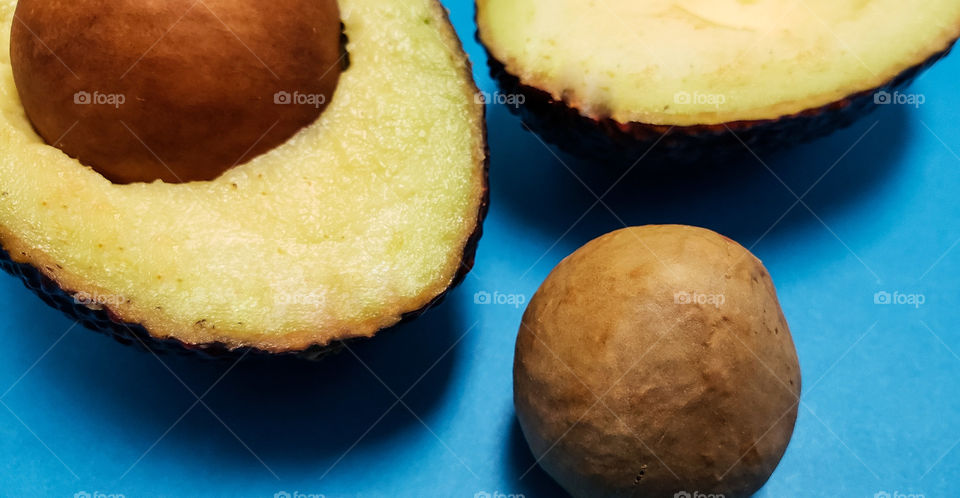 cut avocado on blue background.