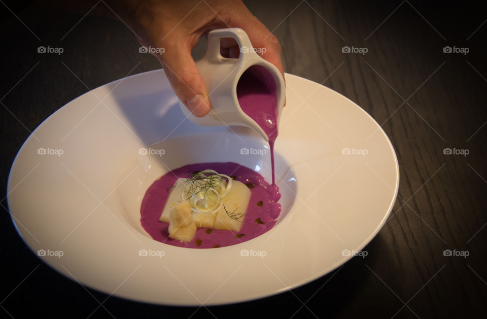 Close-up of a person pouring cream