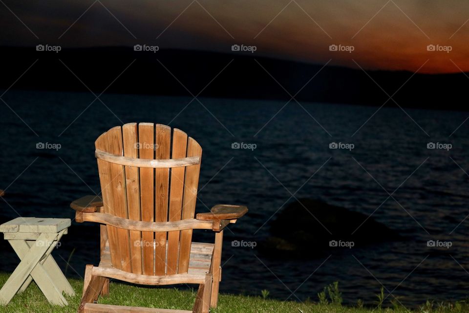 Wood Adirondack  chair on mountain lake at sunset, Chateaugay lake in the Adirondack mountains 