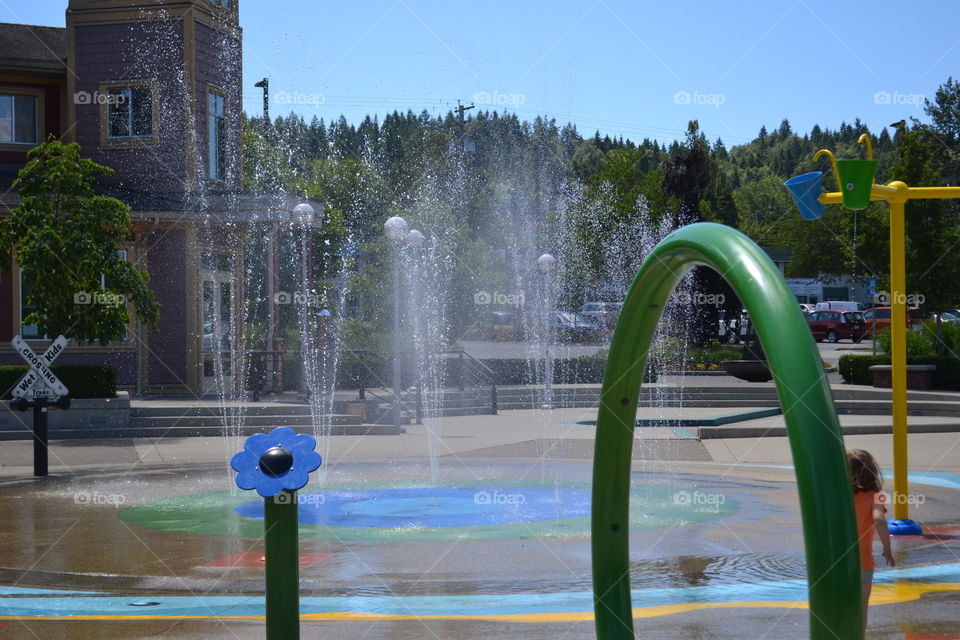 Green water spray arch at children's outdoor water park