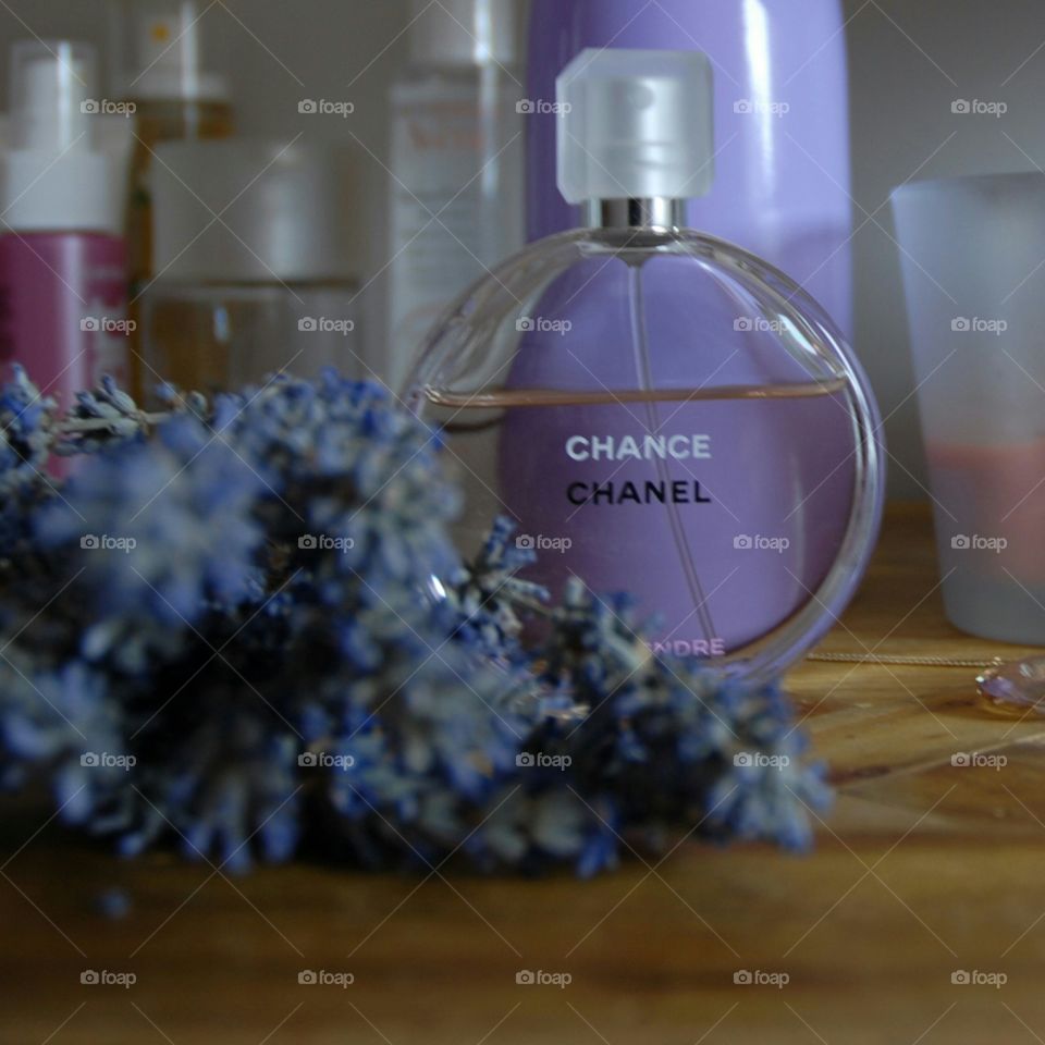 Se refleja una mañana de verano con la luz entrando por la ventana . El elegante  frasco de perfume de "Chanel" trasluce el color lavanda del jarrón de atrás dándole una sofisticada nota de color , ayudando a sentir el olor a colonia recluida dentro.