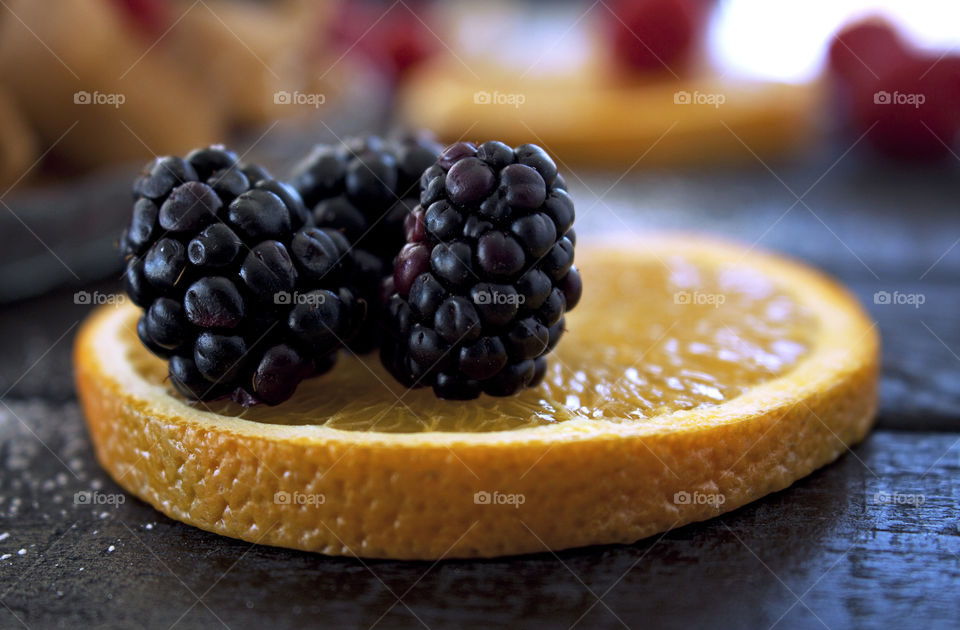 Orange slice with blackberries closeup