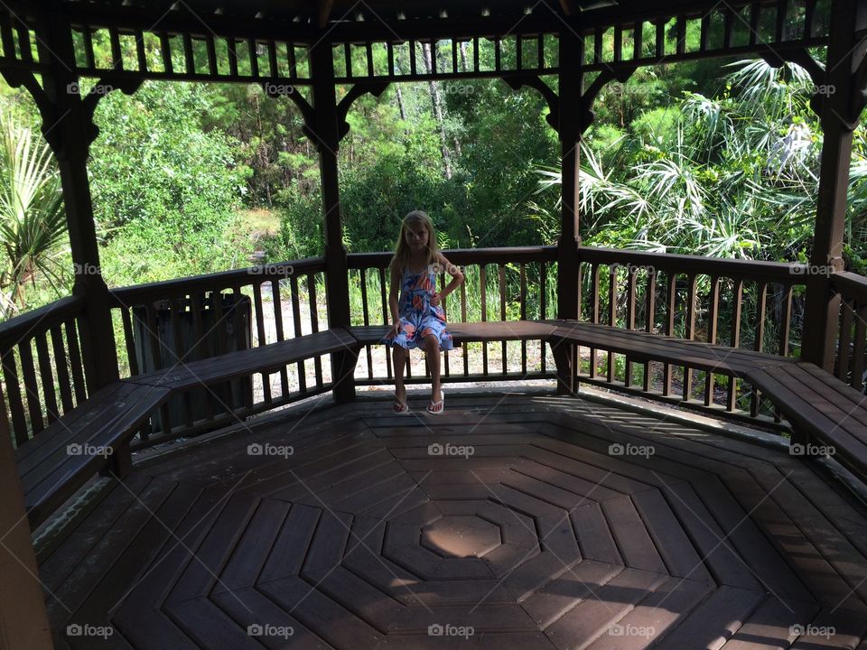 little girl resting under a pavillion at a park