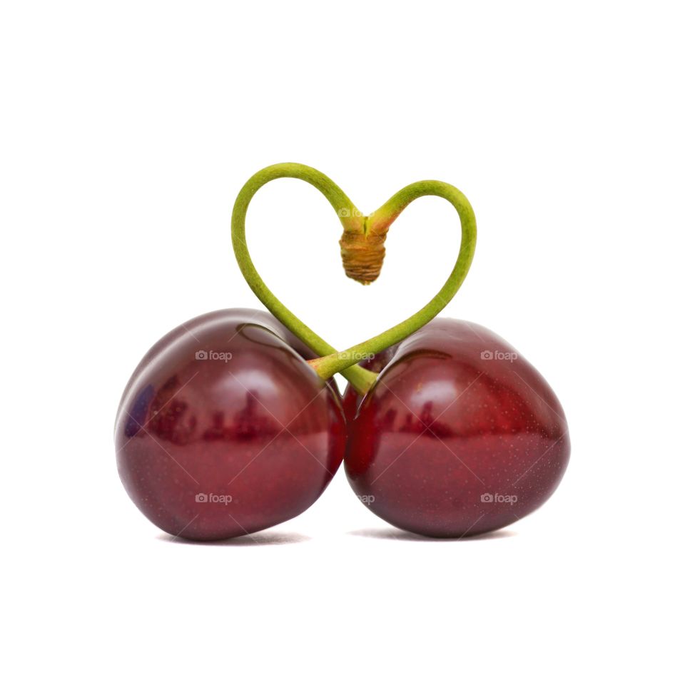 Heart chape from two sweet cherry on a white background