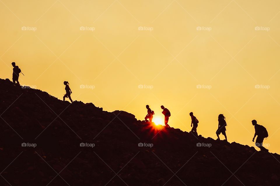 Silhouettes of hikers at sunset