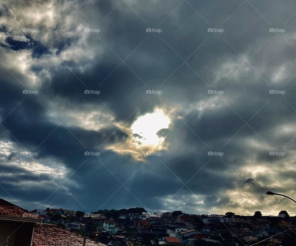 Virou noite?
A chuva vem chegando, embora o sol esteja resistindo.
Não gosto de nuvens escuras…

Has it turned into night?
The rain is coming, although the sun is resisting.
I don't like dark clouds...