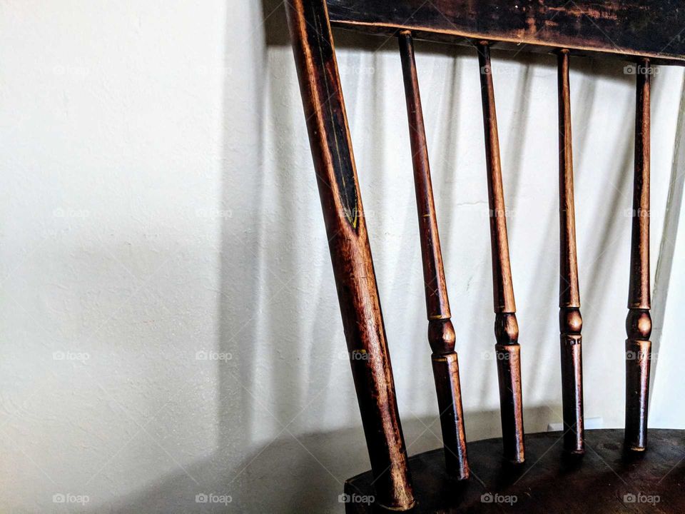 close up of an antique wooden chair with shadow