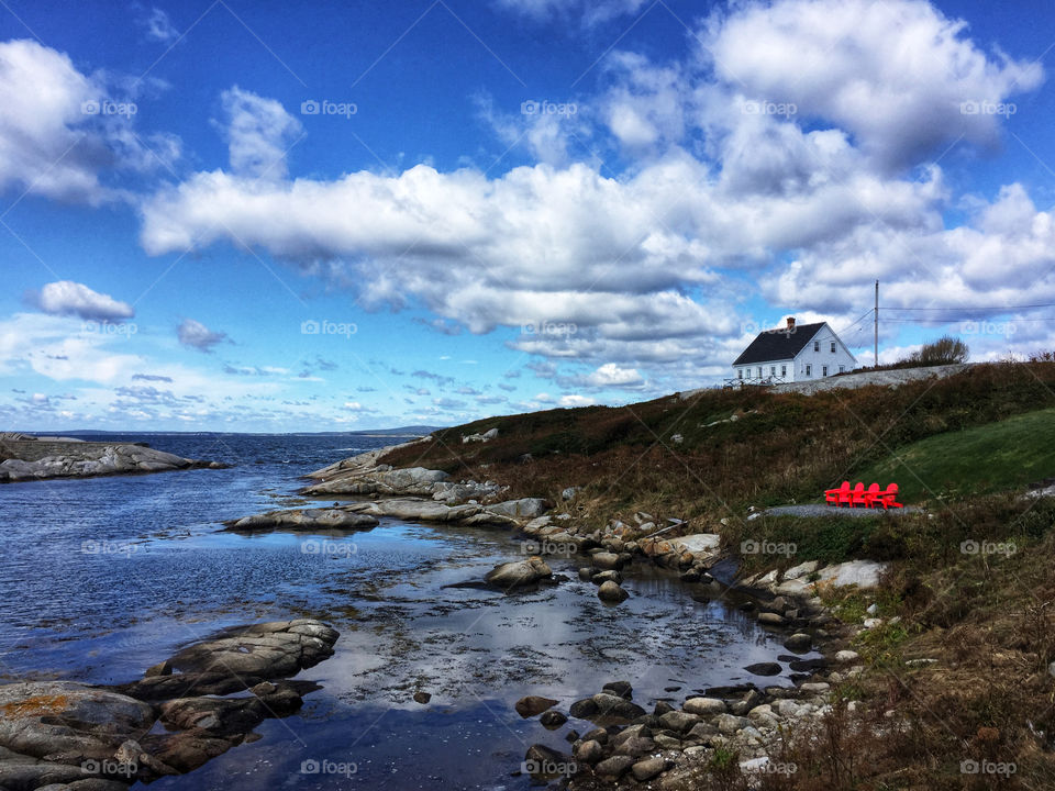 Red Adirondack chairs on promontory on Nova Scotia coast