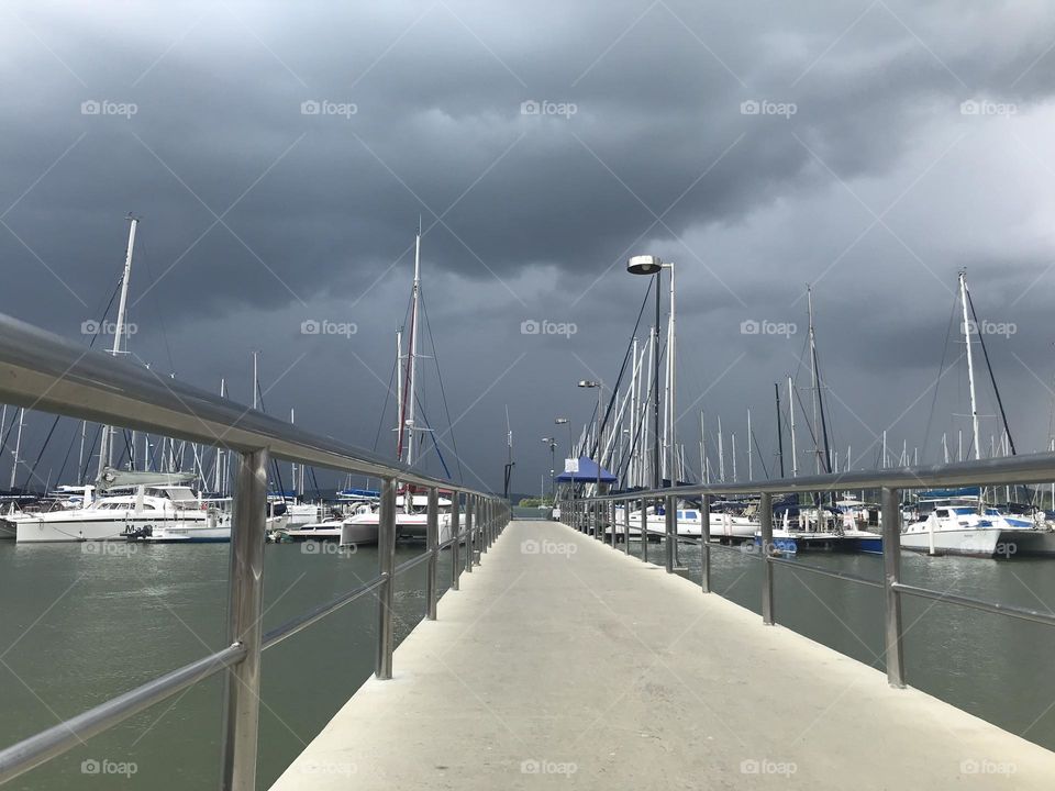 Concrete pier of a marina in bad weather approaching