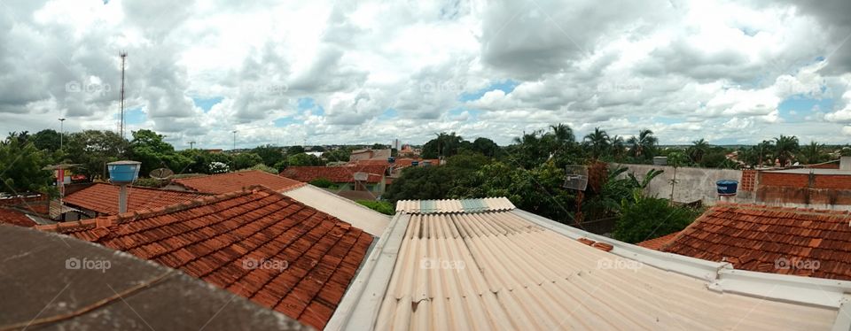 Imagem panorâmica sobre os telhados em cidade pequena do interior.