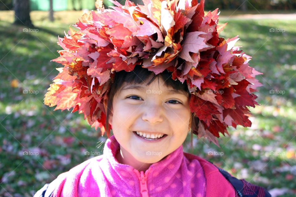 Happy child in autumn leaves wreath