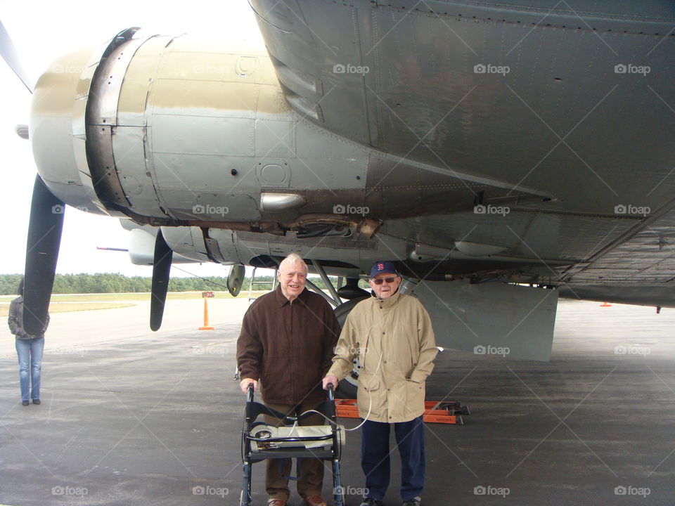 Two old friends & Veterans of Korean War & WWII standing under vintage Bomber at private airport air show. These Vets now use a Walker & breathes with aide of Oxygen.🇺🇸