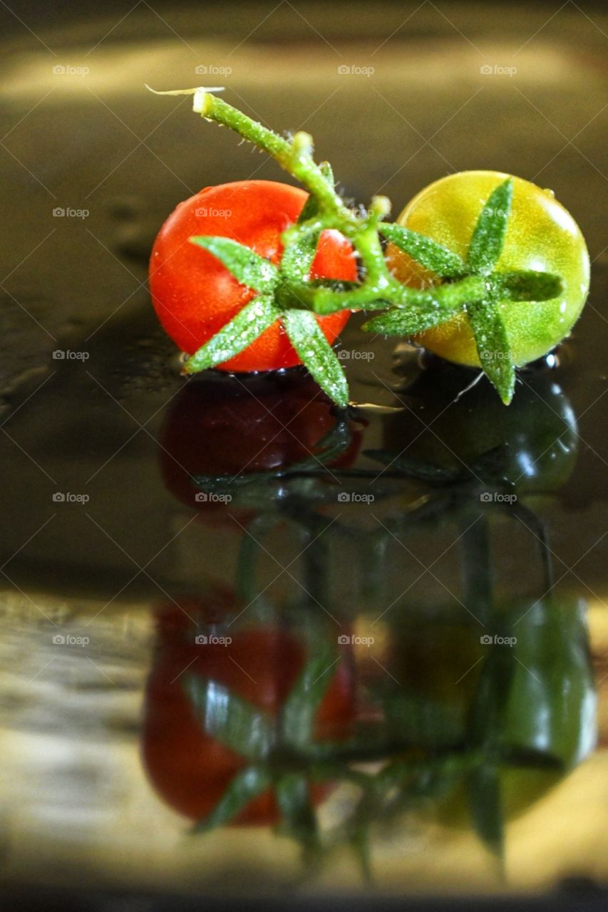 Red and green tomatoes on a black plate