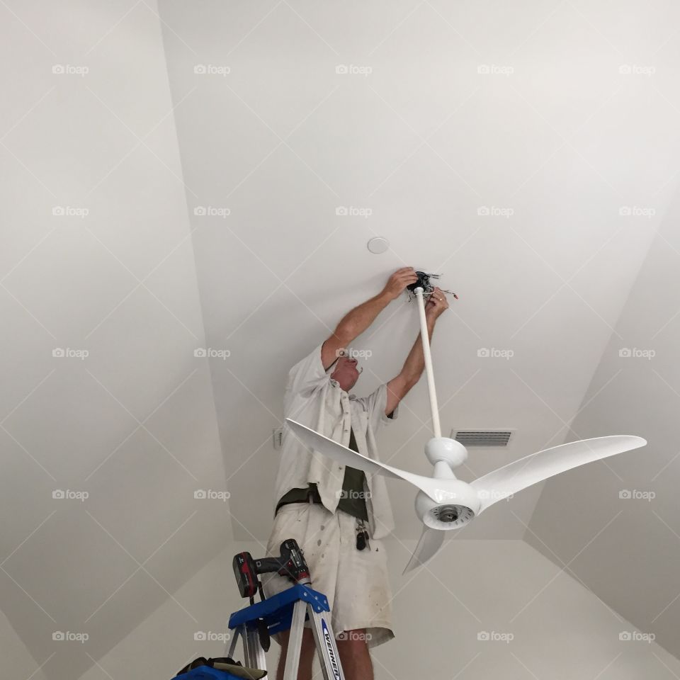 Man working and hanging a ceiling fan