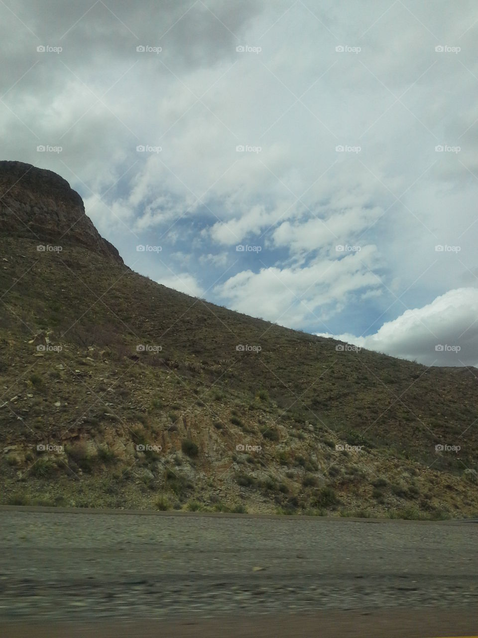 Green, Scrubby Mountain Against Blue Cloudy Sky.  Dessert Landscape, El Paso, Texas.  American Southwest