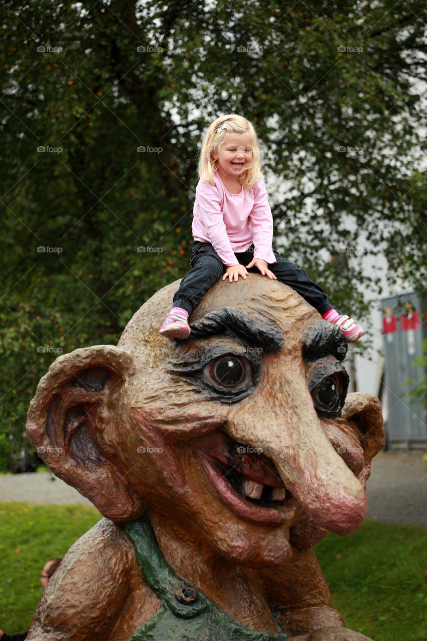 Little girl on a wooden troll in Norway