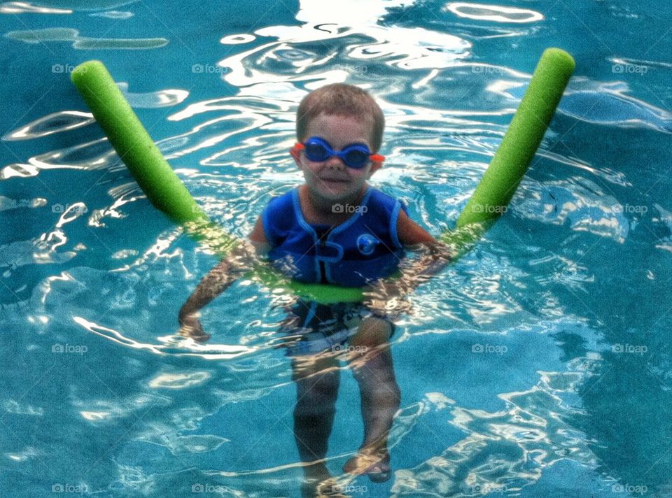 Boy Floats with Noodle