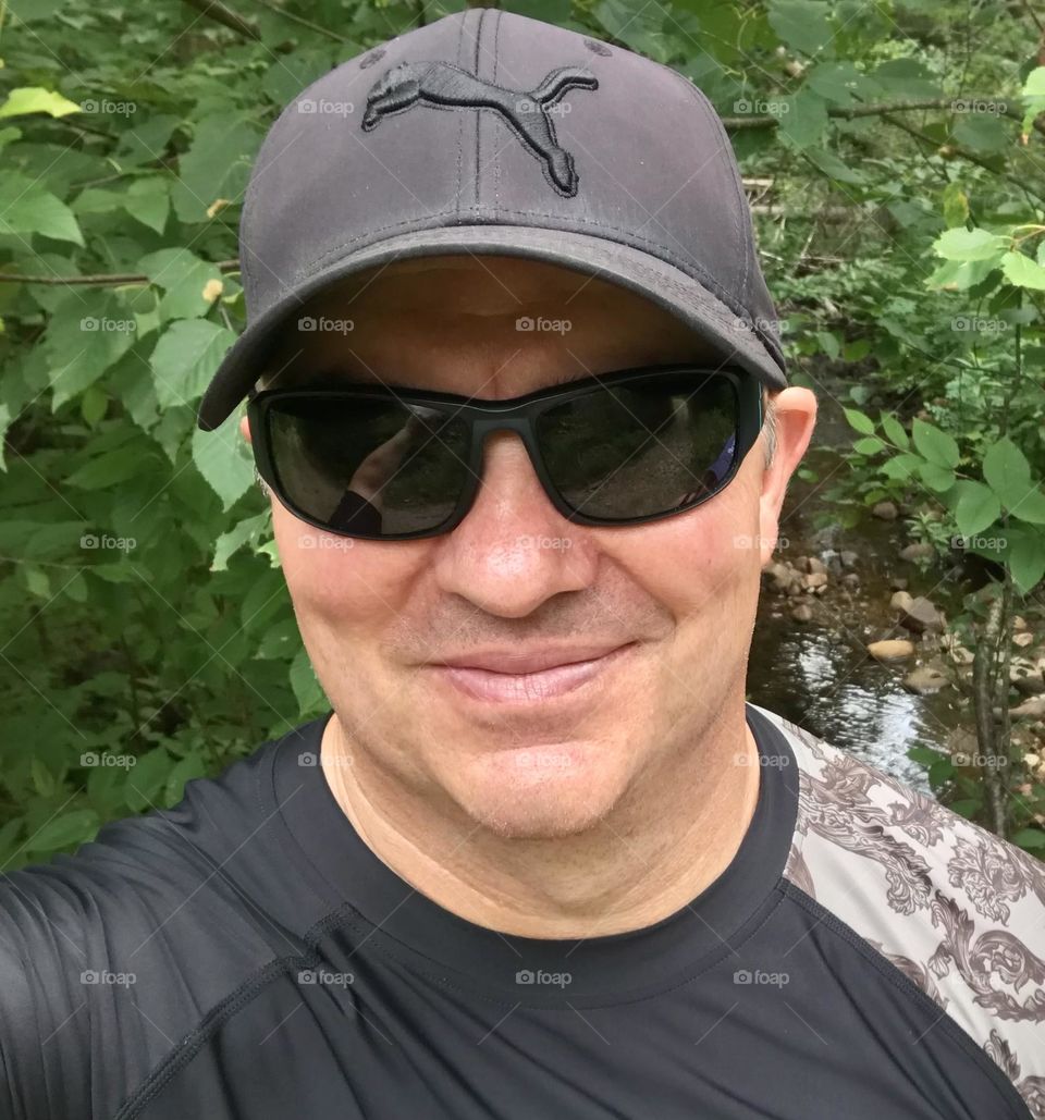 A man happy to be out in nature getting ready to kayaking.