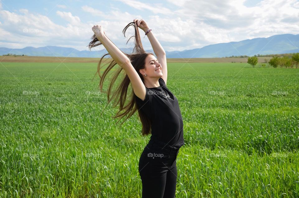 Woman with beautiful natural hair on green field background