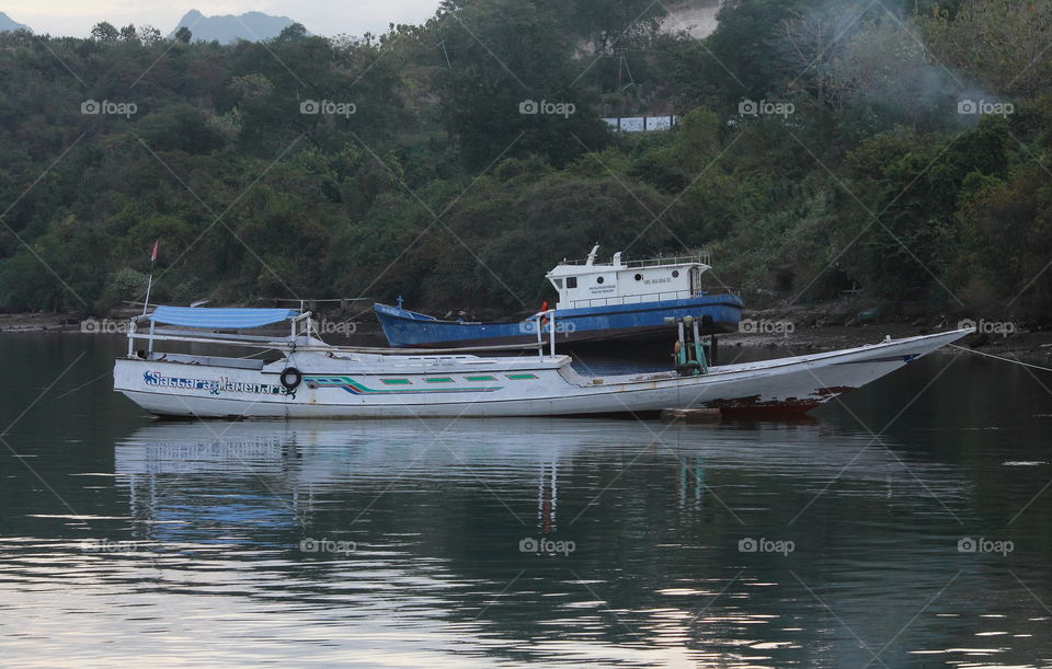 An engine boot parking site at the one bay harbour. Kind pleased of one tourism usefull, or just fishery at the one moment time . The engine boot looks for medium - large size category in to the water - sea transport.