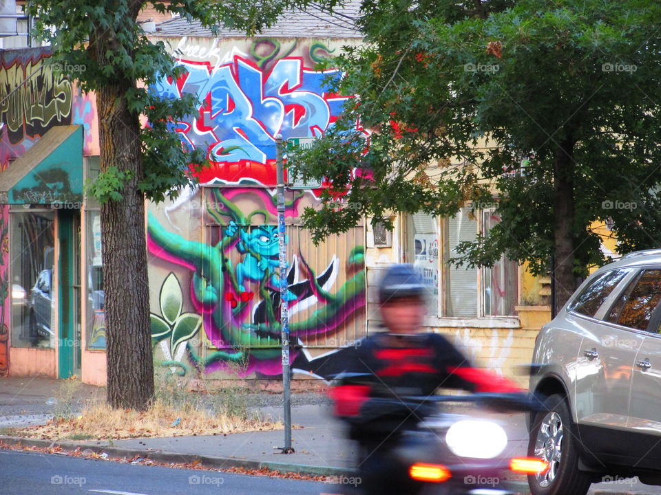 blurred vision of a person on a motorcycle with the background of graffiti art on the streets of Sacramento California