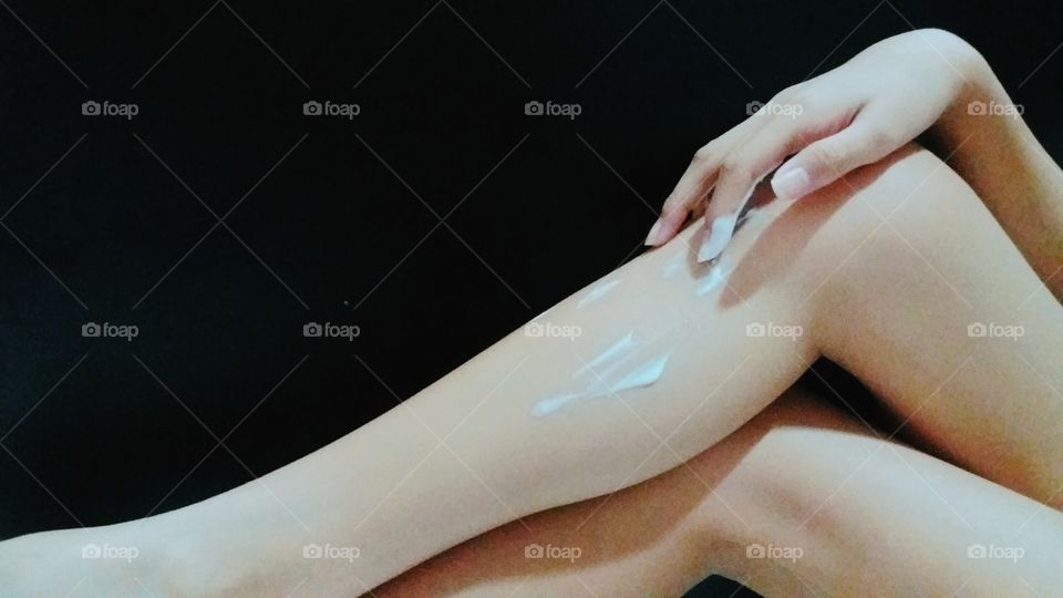 Woman applying cream to her leg