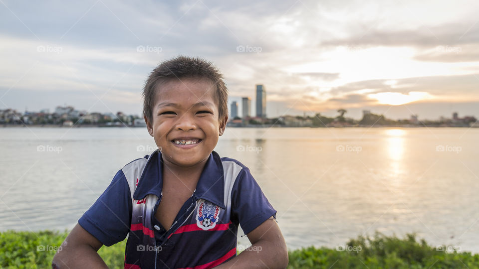 Kid smiling with the sunset as a background 