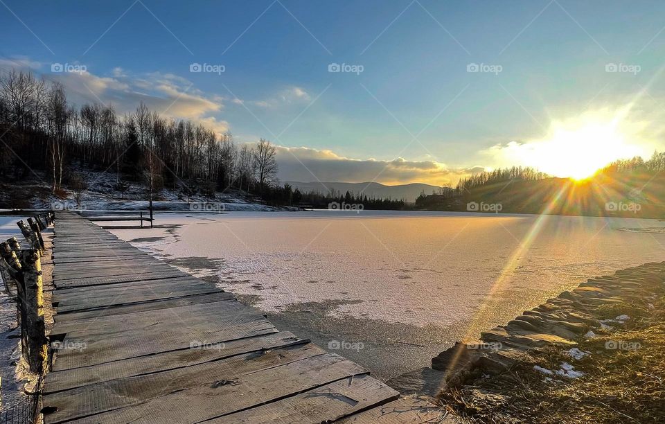 Winter sunset on the lake in mountains