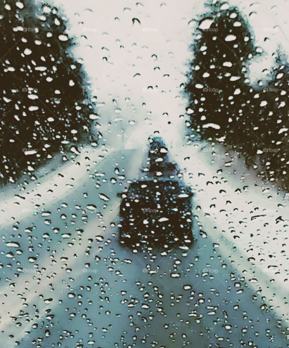 raindrops on car winshield while driving on a rainy day in the winter