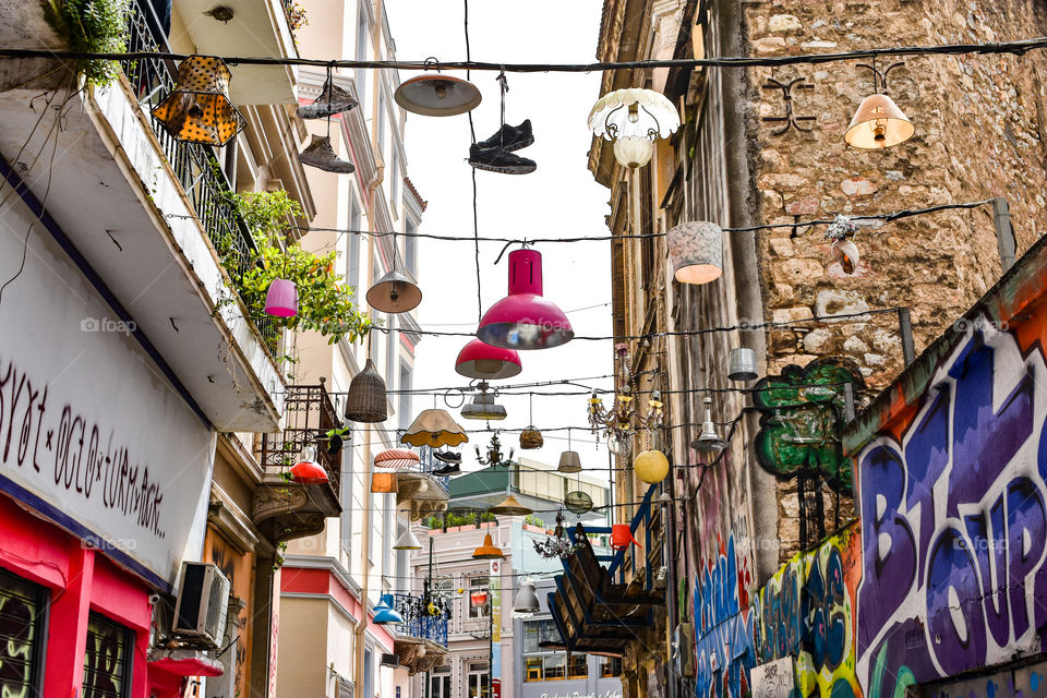 lamps and shoes hanging on ropes in a street