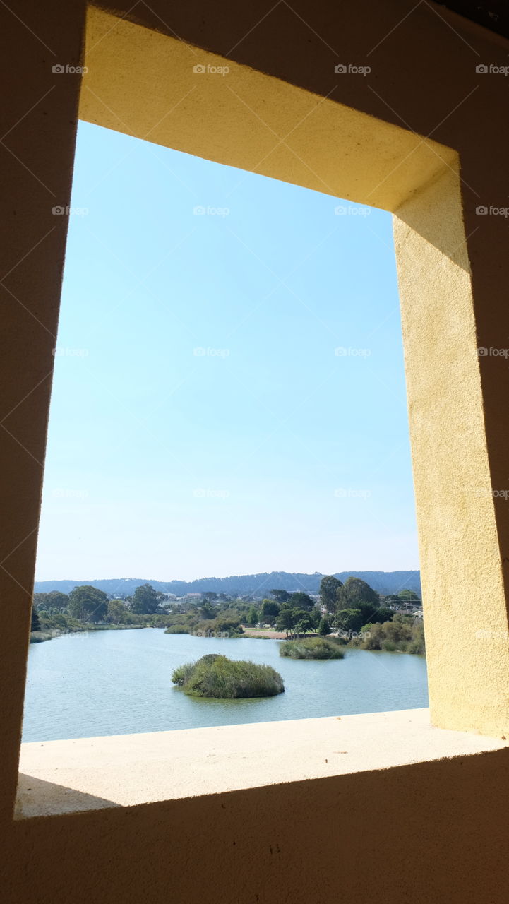 A window overlooking a manmade lake