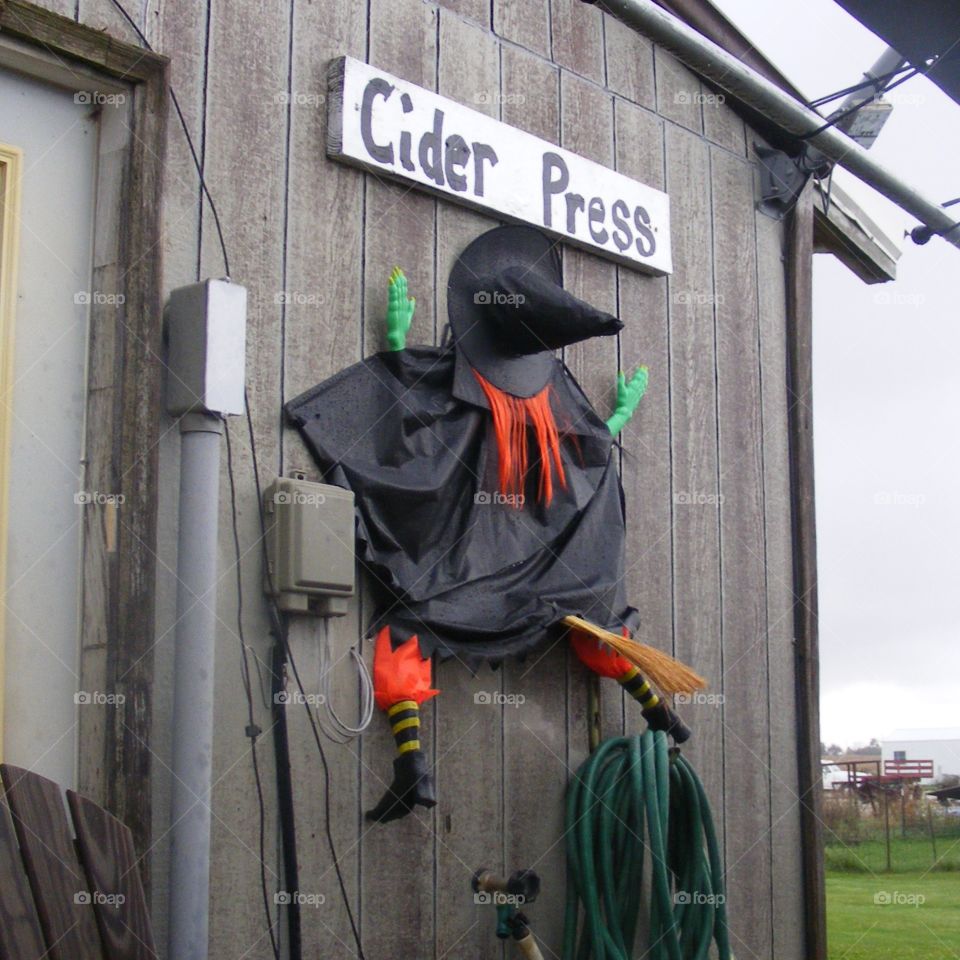 Halloween decoration of a witch that smashed into the side of a barn