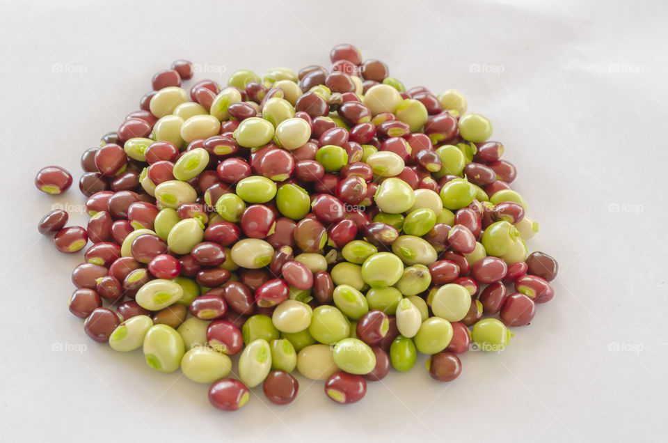 Red And Green Pigeon Peas Against White Background