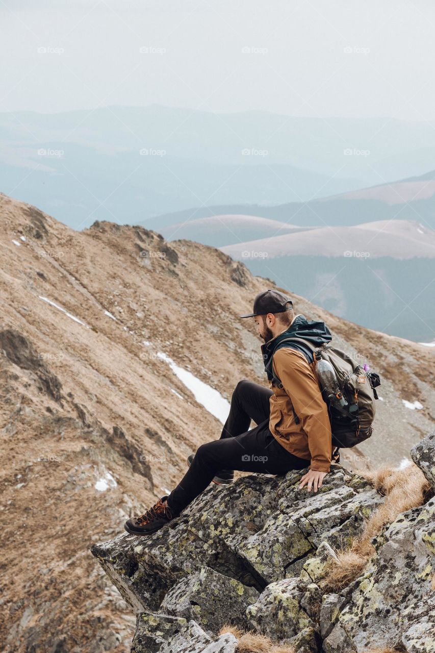 hiker looking down from a mountain top