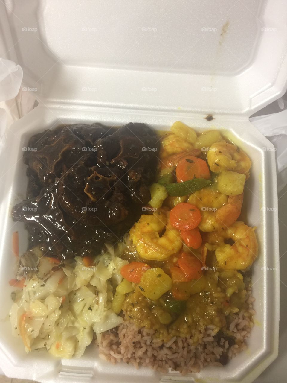 Curried Shrimp/ oxtails combination steamed cabbage with red beans and rice.