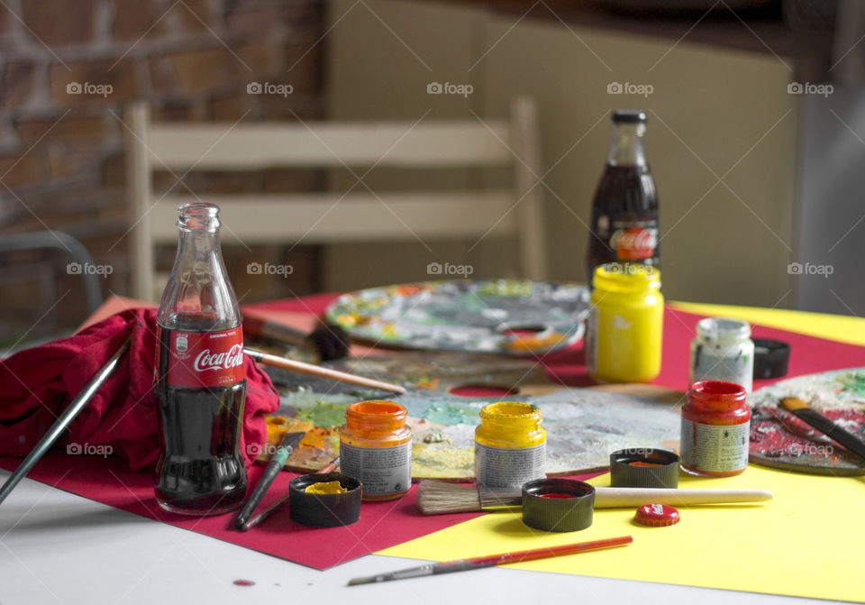 Coca cola and painting tools on the table