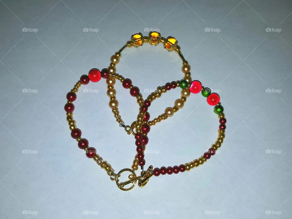 Homemade bracelets in red, gold and a bit of green.