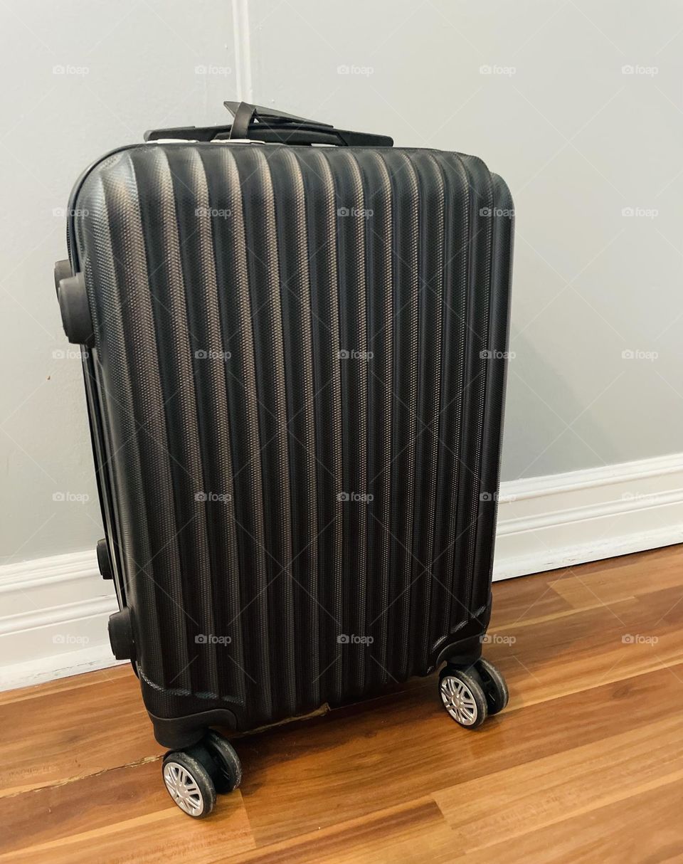 Suitcase ready for a trip, carry on for the airplane, hard sided suitcase, black rolling suitcase packed for a trip, packing for vacation