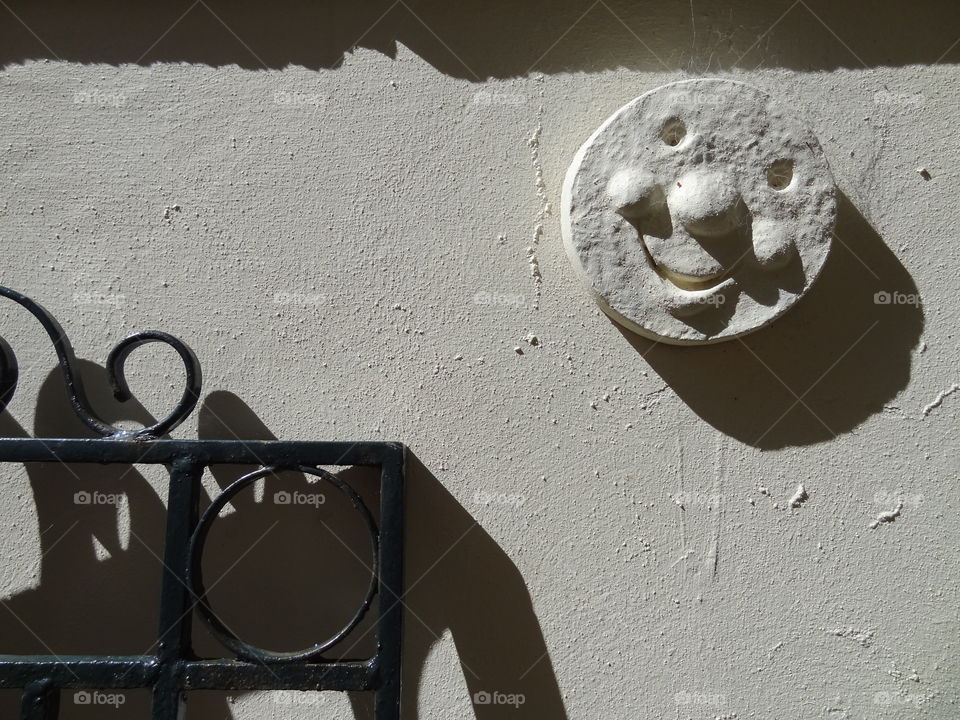 Garden Wall. Smiley face above the gate to the garden