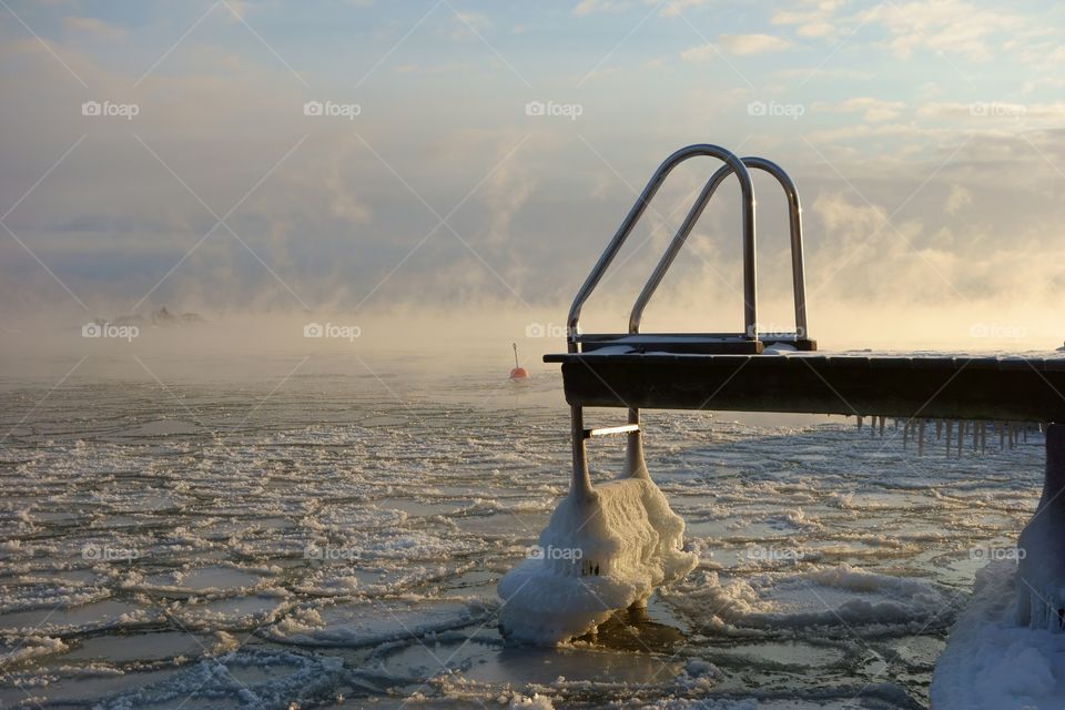 Ice covered swimming jetty and buoy in the freezing Baltic Sea in Helsinki, Finland