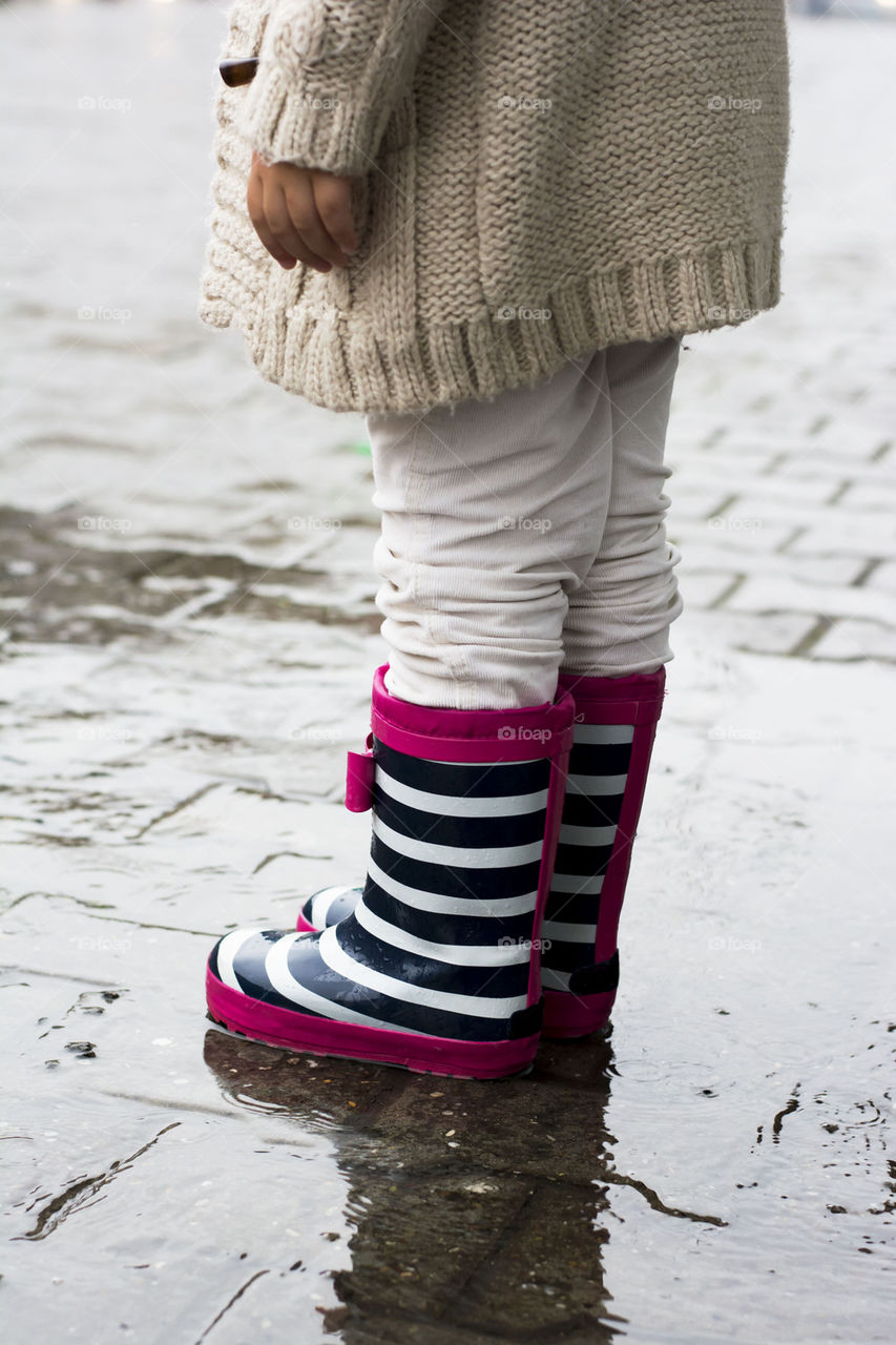 little girl standing in the rain