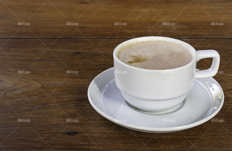 Hot coffee in white glass on wooden table