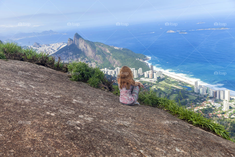 Young girl looking at the city of Rio de Janeiro from the top of the mountain