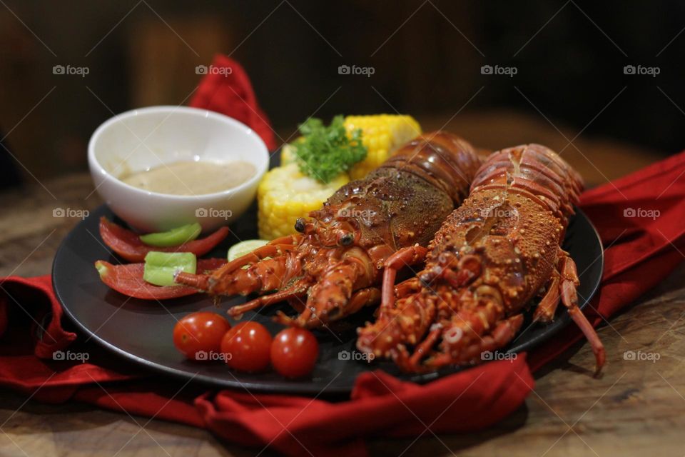 Lobster creamy garlic Lobster served with corn, tomatoes, lemon wedges, cherry and Asian-style creamy garlic sauce.