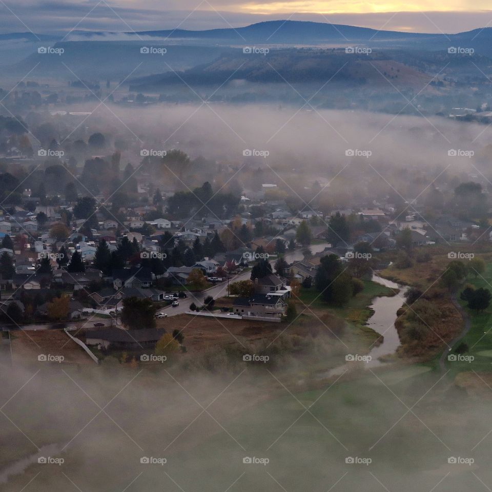 View from the Ochoco State Scenic Viewpoint of the town of Prineville below in Central Oregon on a foggy fall morning. 