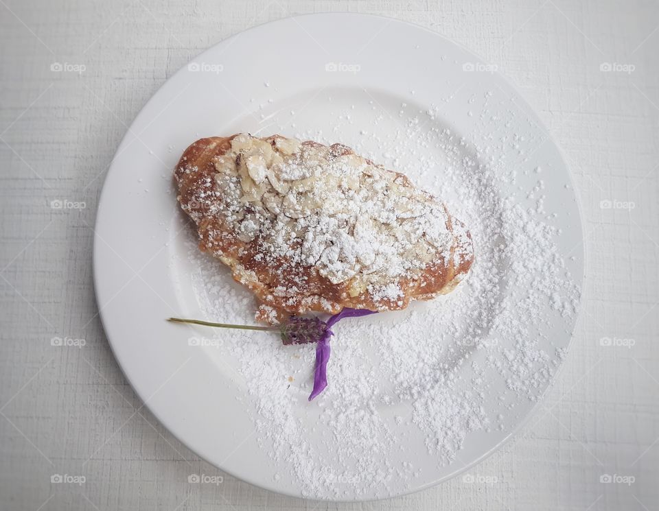 Toasted Almond Croissant resturant sweet treat icing sugar plate cafe