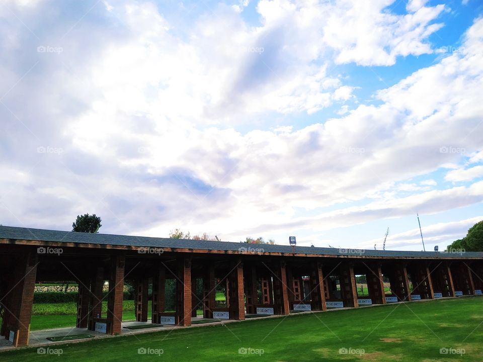 Wooden canopy on the driving range golf. With beautiful cloudy sky view.